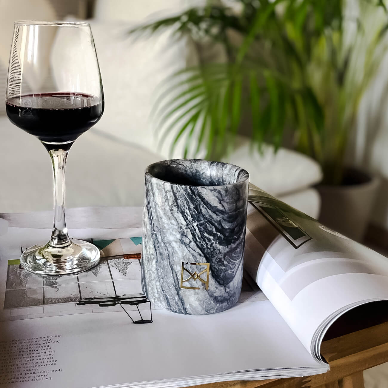 Bougie parfumée en marbre élégante, idéal pour la décoration intérieure, avec verre de vin rouge et magazine ouvert.